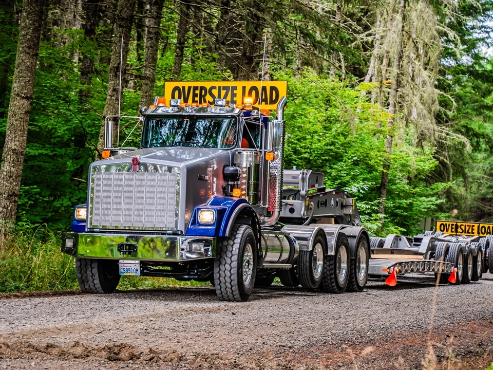 Kenworth T800W con carga sobredimensionada en el bosque